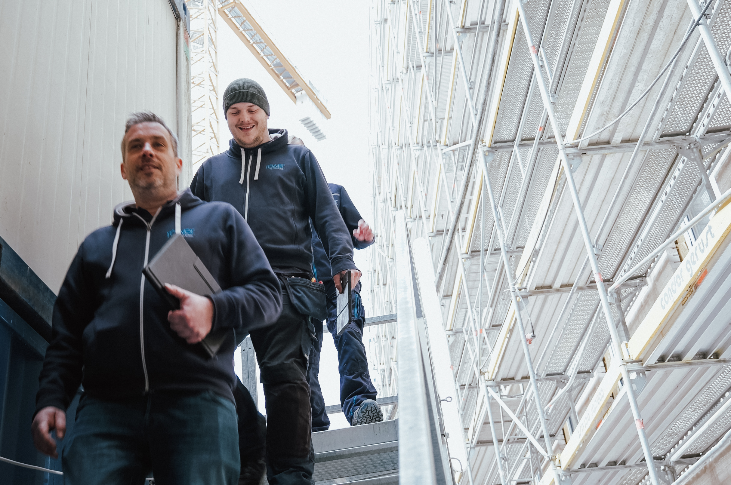 Zwei Mitarbeiter bei Röwer, die eine Außentreppen runter gehen.